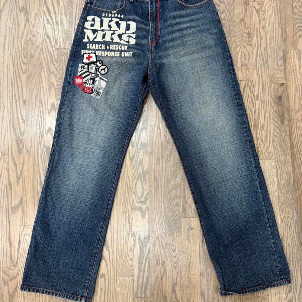 Akademiks blue jeans with white text and graphic patches, size 34